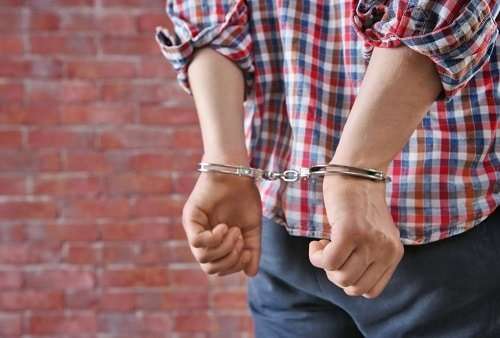 hands behind his back on handcuffs